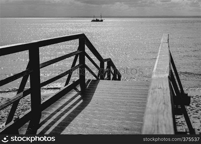 Wooden bridge for walks to the beach, black & white