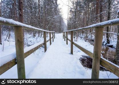 Wooden bridge in snow forest - close up