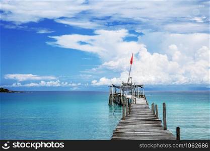 Wooden bridge on sea with the blue sky background.