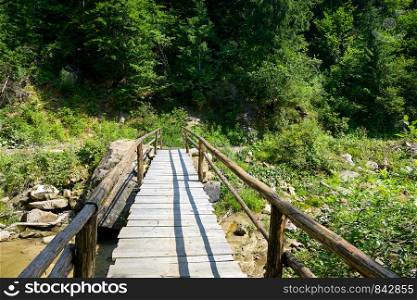 Wooden bridge over mountain river.
