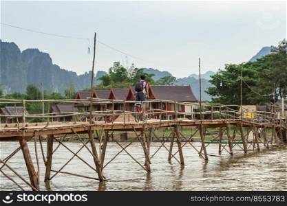 Wooden bridge over river song to riverside guesthouse, Vang vieng, Laos.