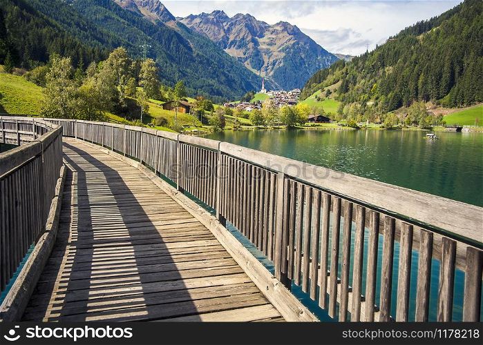 Wooden bridge over the Muhlwald reservoir in Muhlwald South Tyrol Italy