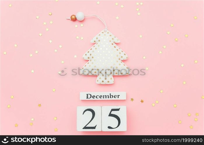 Wooden calendar December 25, textile christmas tree and stars confetti on pink background. Merry christmas concept. Top view Flat lay Template for design, greeting card, postcard.. Wooden calendar December 25, textile christmas tree and stars confetti on pink background. Merry christmas concept. Top view Flat lay Template for design, greeting card, postcard