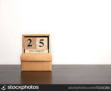 wooden calendar of cubes with the date of December 25 and brown box, festive Christmas background