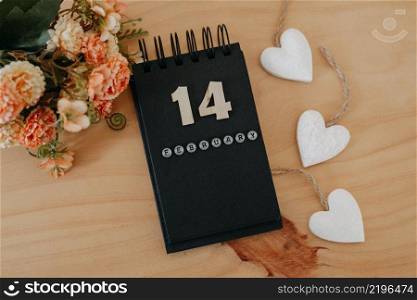 Wooden calendar on February 14 with roses and heart. Happy Valentines Day concept