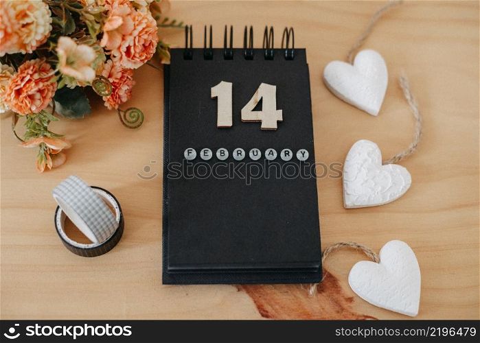 Wooden calendar on February 14 with roses and heart. Happy Valentines Day concept