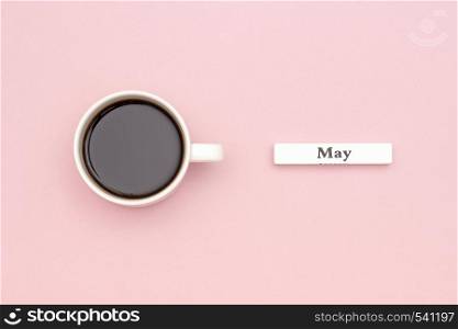 Wooden calendar spring month May and Cup of black coffee on pastel pink paper background. Concept Hello May Creative Top view Flat Lay Greeting card.. Wooden calendar spring month May and Cup of black coffee on pastel pink paper background. Concept Hello May Creative Top view Flat Lay Greeting card