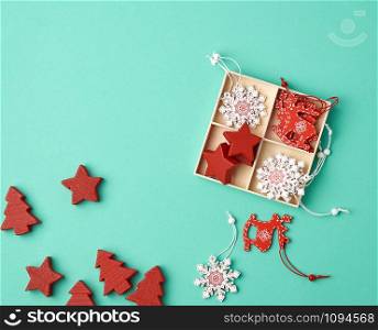 wooden carved Christmas decorations for the holiday tree on a green background, top view
