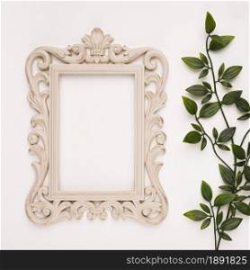 wooden carving frame near artificial leaves white backdrop. Resolution and high quality beautiful photo. wooden carving frame near artificial leaves white backdrop. High quality and resolution beautiful photo concept