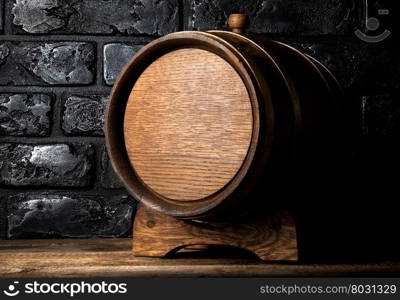 Wooden cask on table near black brick wall