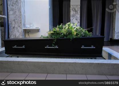 Wooden casket with funeral flowers, cremation ceremony