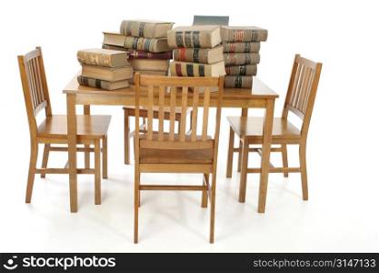 Wooden chairs surrounding wooden table full of old torn and worn law books.