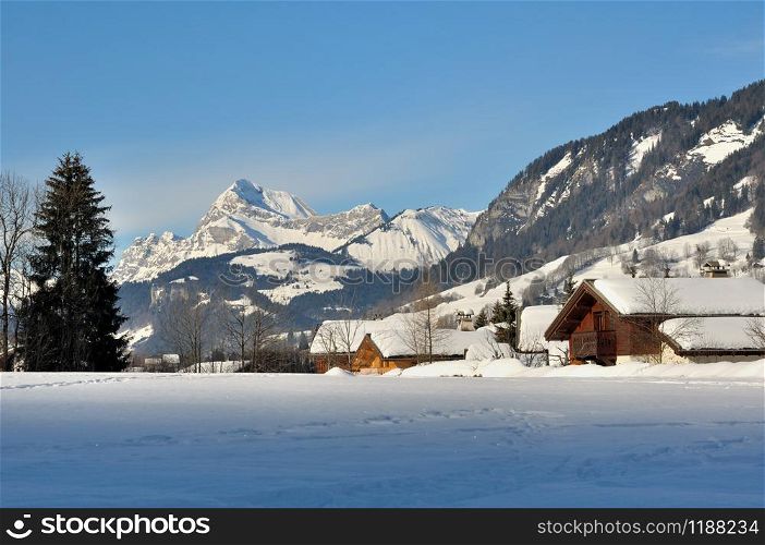 Wooden chalets in a village in the mountains covered with snow