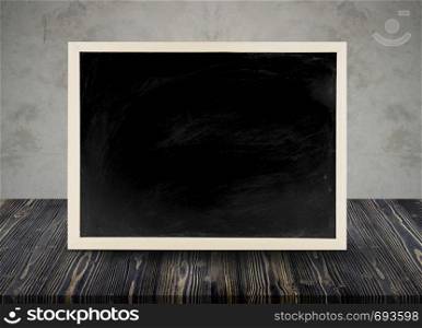 Wooden chalkboard empty table top with cement background, can be used for display your products.