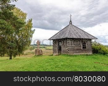 Wooden chapel and stone cross on the top of Savkin hill, Pushkinskiye Gory Reserve, Russia