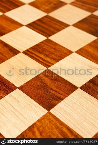 Wooden chess board with brown and yellow squares background . Natural wood