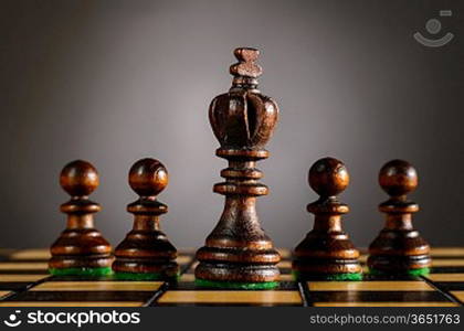 wooden chess pieces on gray background