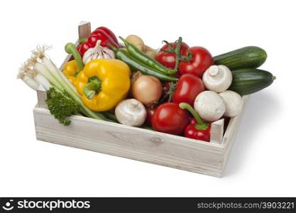 Wooden chest with fresh vegetables on white background