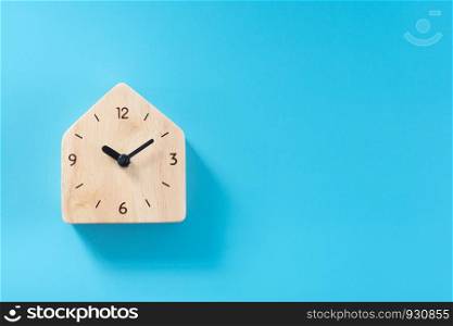 Wooden clock on blue background.