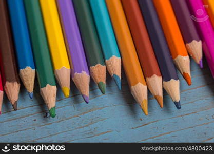 Wooden colorful pencils, on a blue old table