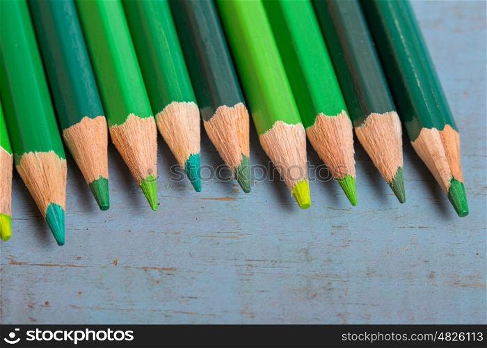 Wooden colorful pencils, on a blue old table
