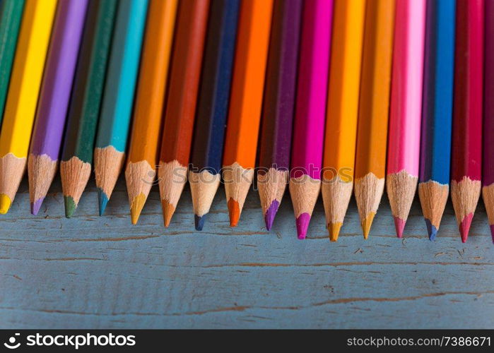 Wooden colorful pencils, on a blue old table