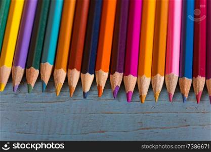 Wooden colorful pencils, on a blue old table