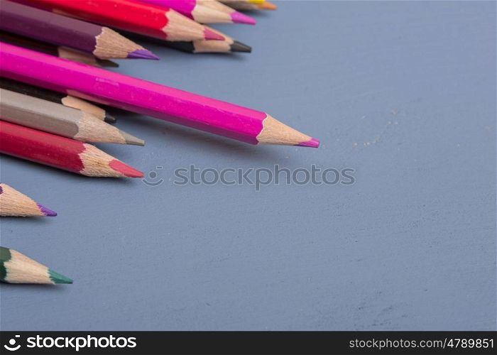 Wooden colorful pencils, on a blue wooden background