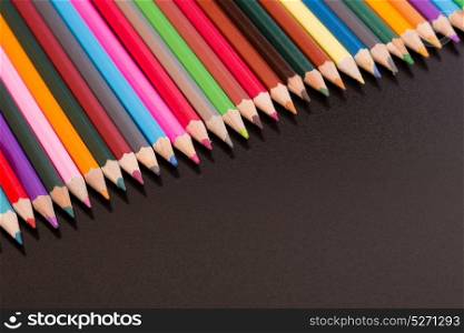 Wooden colorful pencils, on a dark background