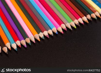 Wooden colorful pencils, on a dark background