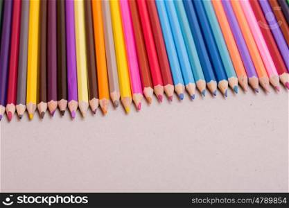 Wooden colorful pencils, on a grey paper