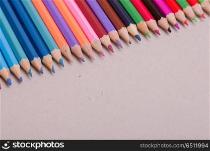 Wooden colorful pencils, on a grey paper. colorful pencils