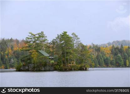 Wooden cozy cabin on a small island on a scenic lake