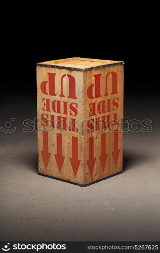 Wooden crate on warehouse floor, upside-down.