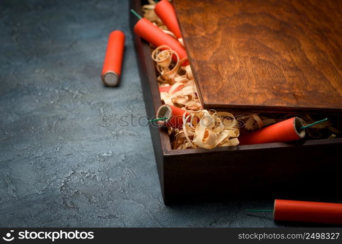 Wooden crate with red dynamite firecracker tnt sticks on table with copy space.