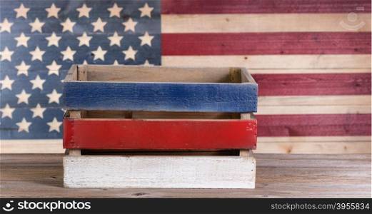 Wooden crate with vintage wooden USA flag in background.
