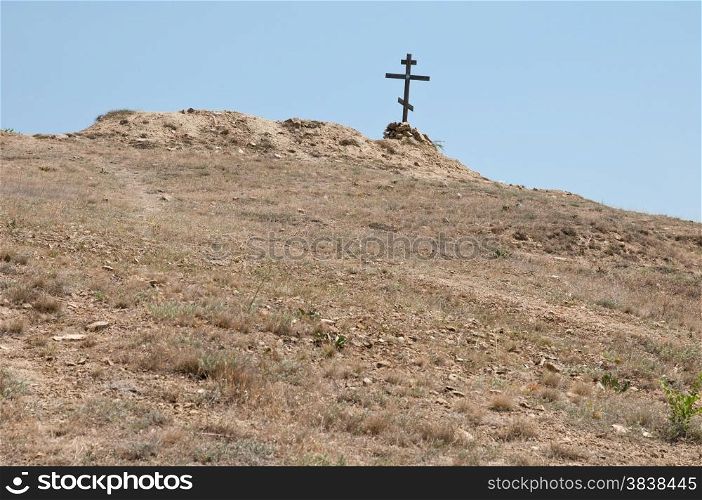 wooden cross on a lifeless dry hill