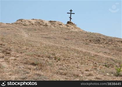 wooden cross on a lifeless dry hill