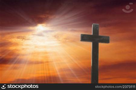 Wooden cross stand against a dramatic evening sky with radiant beams penetrating clouds