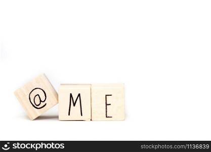 Wooden cube with a commercial At Sign symbol and the word Me isolated on white background, space for text close-up. Wooden cube with a commercial At Sign symbol and the word Me isolated on white background, space for text