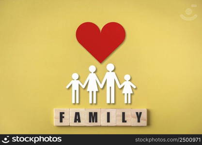 Wooden cube with family text , Family figures with red heart on yellow background , Medical care and health insurance concept.