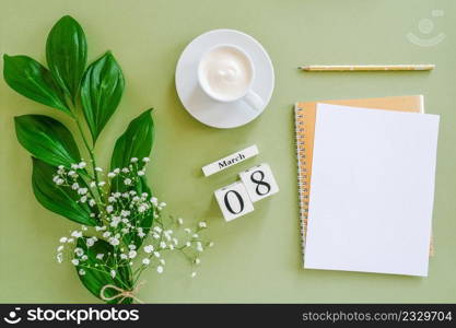 Wooden cubes calendar March 8. Open blank notepad, cup of coffee, bouquet flowers on green background. Concept hello spring Creative Top view Flat lay Mock up.. Wooden cubes calendar March 8. Open blank notepad, cup of coffee, bouquet flowers on green background. Concept hello spring Top view Flat lay Mock up