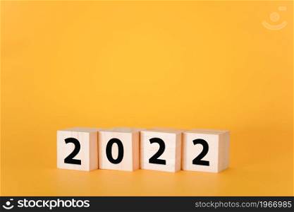 Wooden cubes on a yellow background and 2022. The concept of the New Year and holiday.. Wooden cubes on a yellow background and 2022.