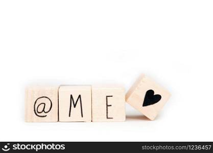 Wooden cubes with a At sign,the word Me and a heart symbol isolated on white background, self love concept social media. Wooden cubes with a At sign,the word Me and a heart symbol isolated on white background, self love concept