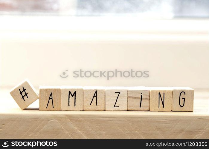Wooden cubes with a hashtag and the word amazing, social media concept background. Wooden cubes with a hashtag and the word amazing, social media concept
