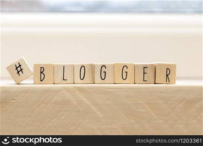 Wooden cubes with a hashtag and the word blogger, social media concept background. Wooden cubes with a hashtag and the word blogger, social media concept