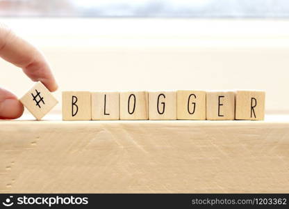 Wooden cubes with a hashtag and the word blogger, social media concept background. Wooden cubes with a hashtag and the word blogger, social media concept