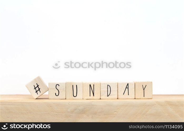 Wooden cubes with a hashtag and the word Sunday, social media concept near white background close-up. Wooden cubes with a hashtag and the word Sunday, social media concept near white background