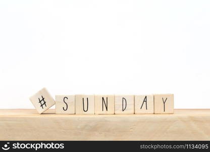 Wooden cubes with a hashtag and the word Sunday, social media concept near white background close-up. Wooden cubes with a hashtag and the word Sunday, social media concept near white background