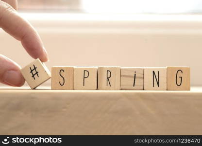 Wooden cubes with hashtag and the word spring, social media concept spring background